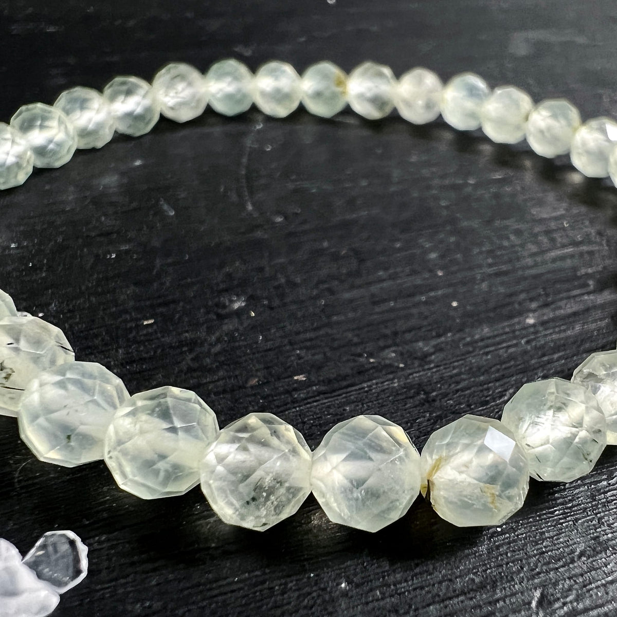 Prehnit Armband | Nahaufnahme halber Kreis | lindgrüne Facettierung | natürliche Einschlüsse sichtbar | Happy Minerals