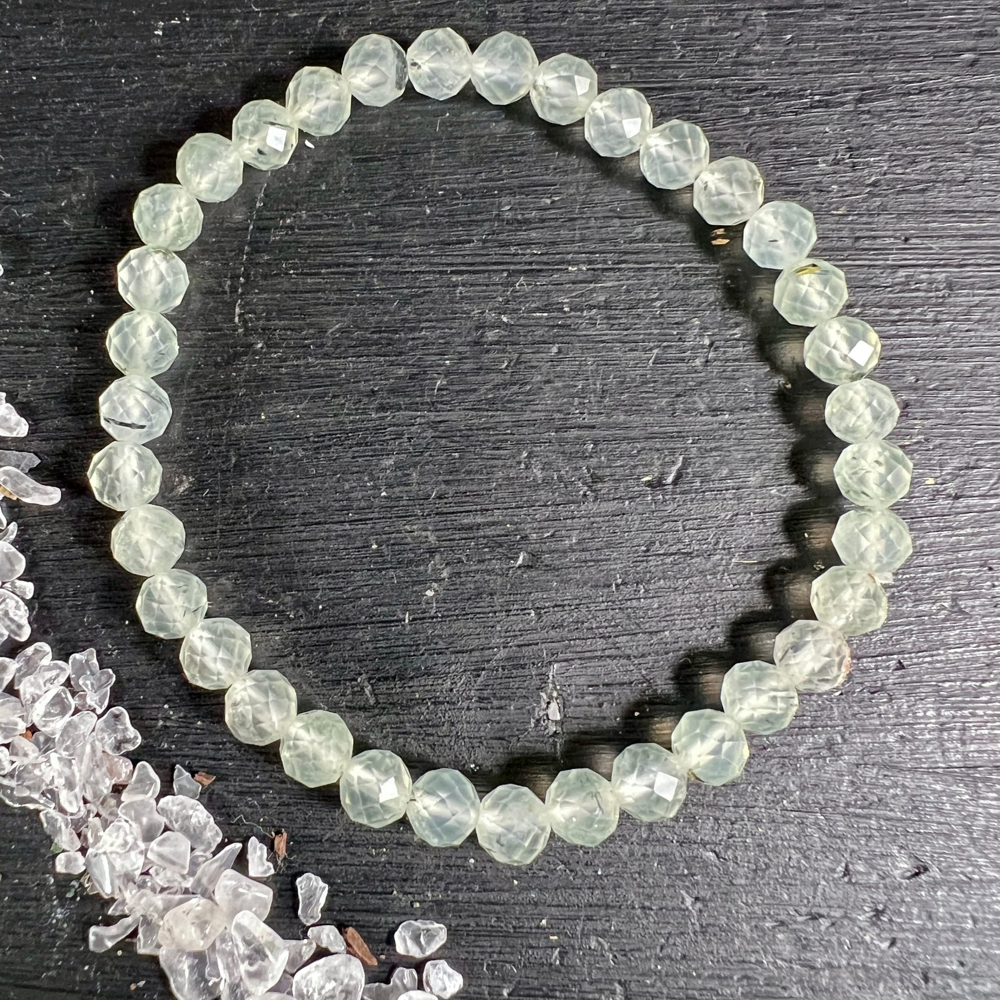 Prehnit Armband facettiert | einzeln von oben | runde Perlen | hellgrüner Schimmer | schwarzes Brett | Happy Minerals