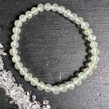 Prehnit Armband facettiert | einzeln von oben | runde Perlen | hellgrüner Schimmer | schwarzes Brett | Happy Minerals