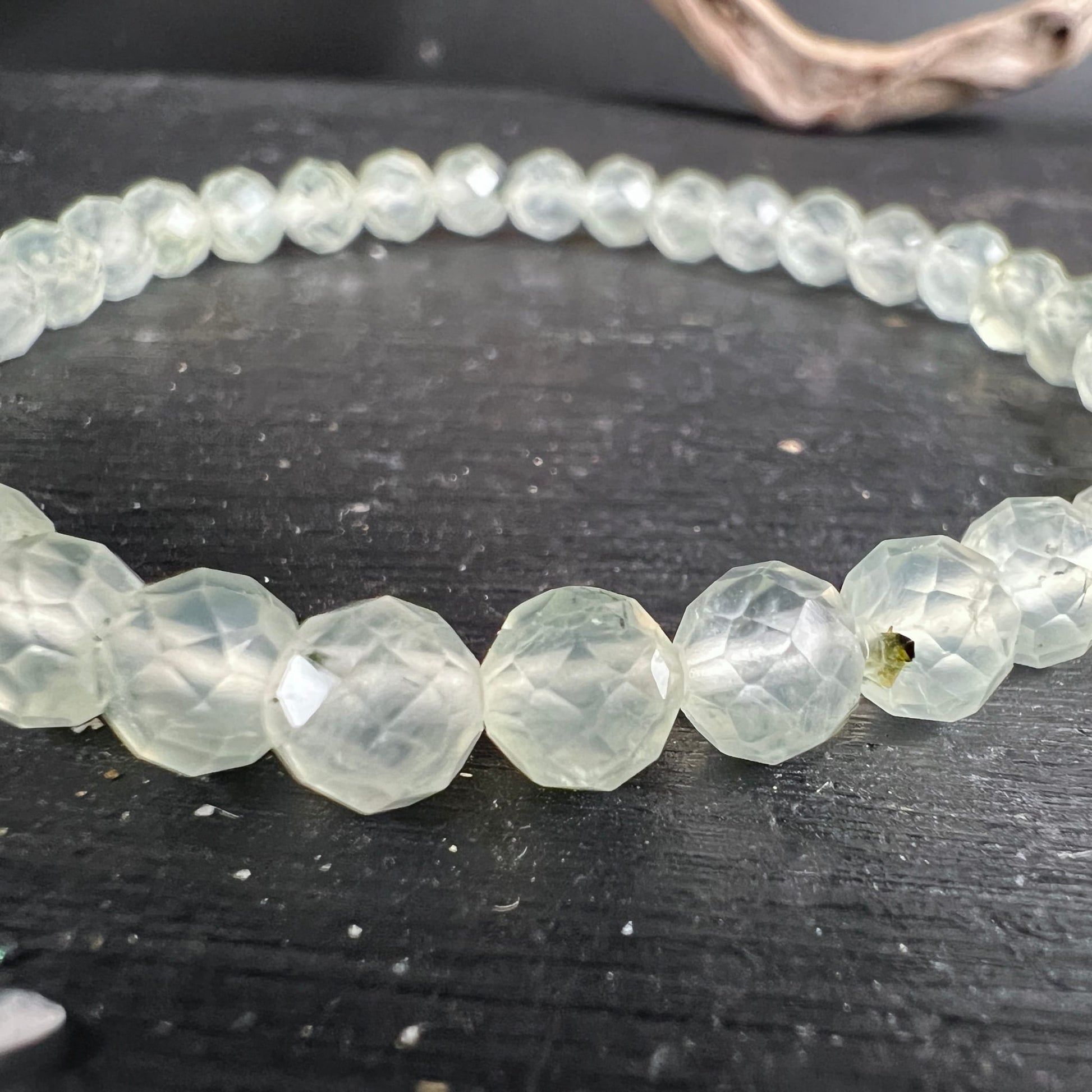 Prehnit Armband facettiert | Nahaufnahme | eisgrüne Facetten glänzen | natürliche Einschlüsse sichtbar | Happy Minerals