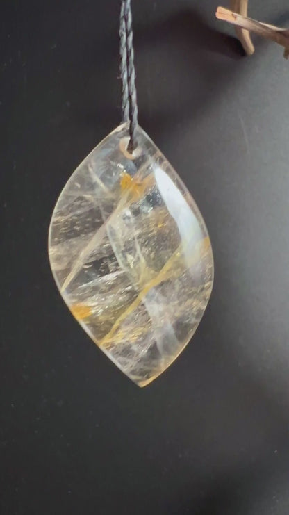 Golden Healer Quarz Anhänger mit goldenen Limonit-Einschlüssen auf dunklem Holz | Happy Minerals