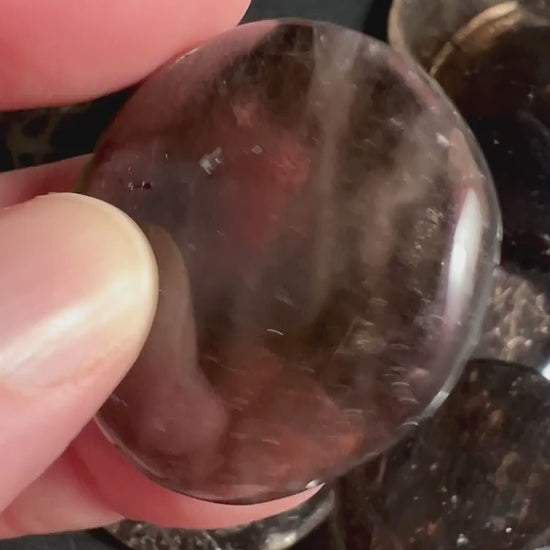 Mehrere Rauchquarz Taschensteine in Hand zeigen Farbvariationen