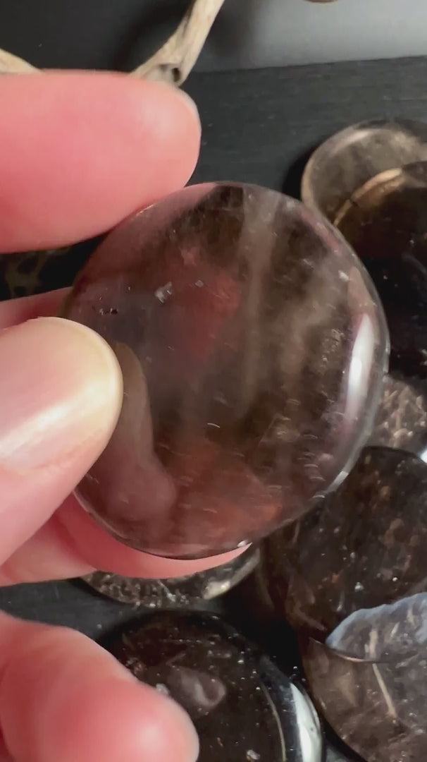 Mehrere Rauchquarz Taschensteine in Hand zeigen Farbvariationen