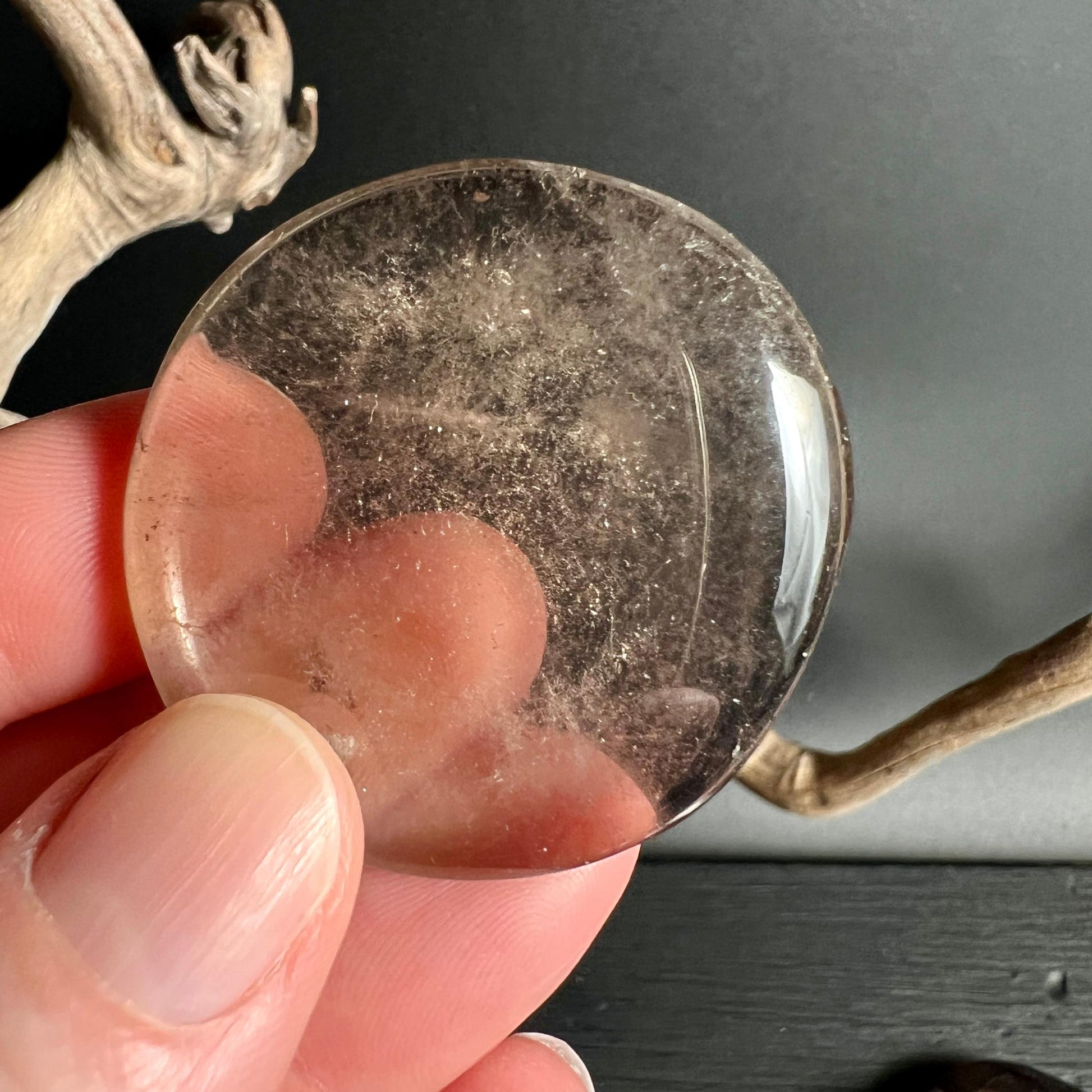 Klarer transluzenter Rauchquarz Handschmeichler in Hand gehalten