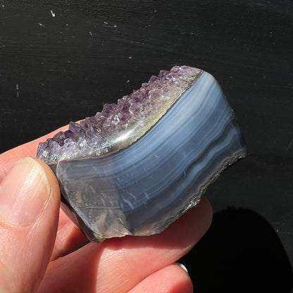 Regenbogen Amethyst Achat Uruguay | Hand hält Seitenansicht | violette Spitzen | polierte Achatbänder blau-grau | Happy Minerals