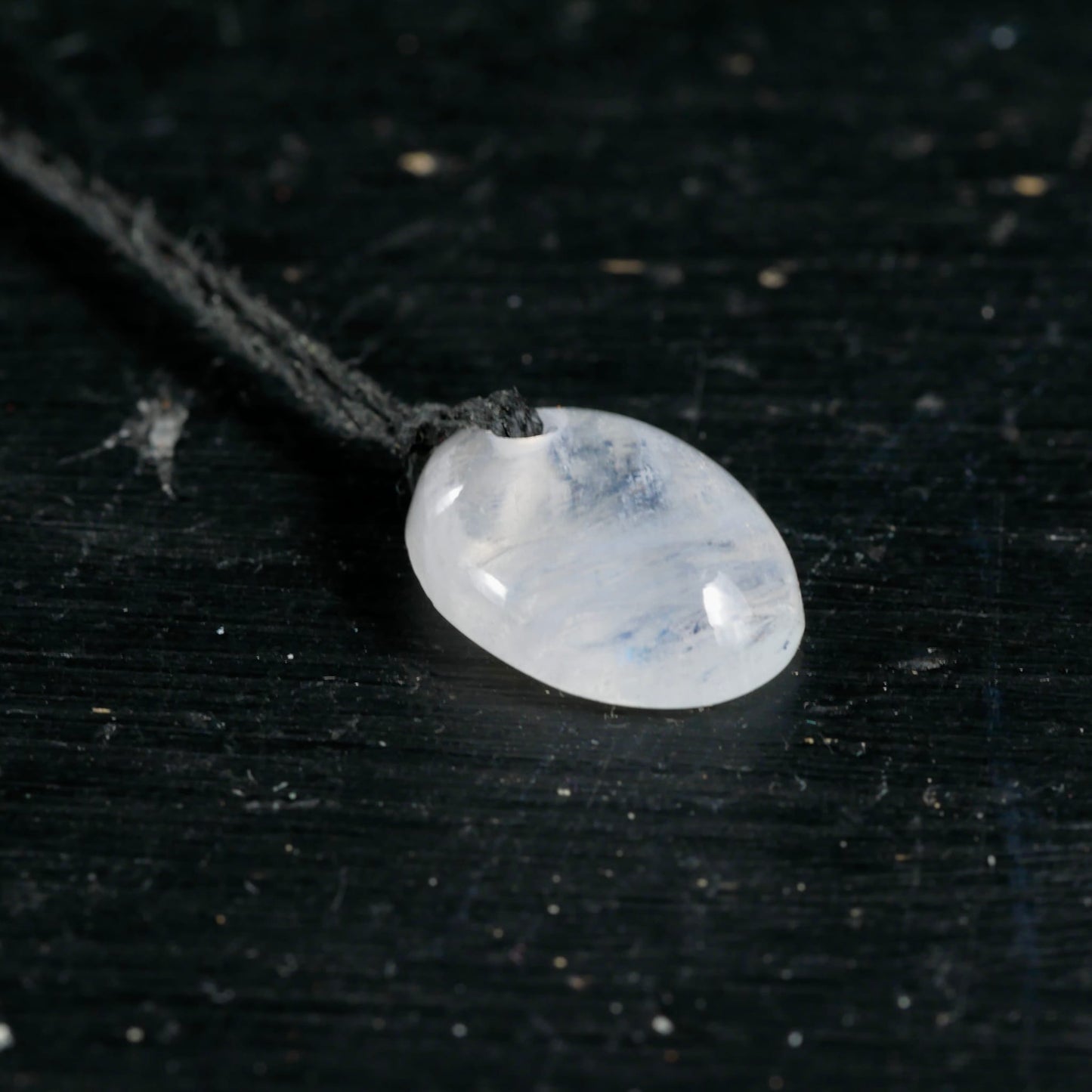 Mondstein Anhaenger oval poliert, milchig-weiss mit blauem Schimmer und Schlieren, an dunkler Kordel | Happy Minerals