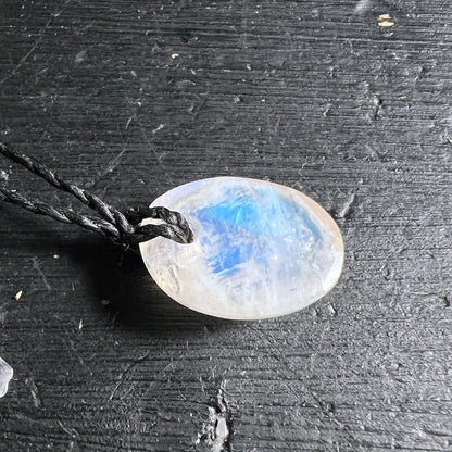 Ovaler Mondstein Anhaenger, milchig-weiss mit blauem Schimmer und feinen Glanzstreifen, an schwarzer Kordel | Happy Minerals