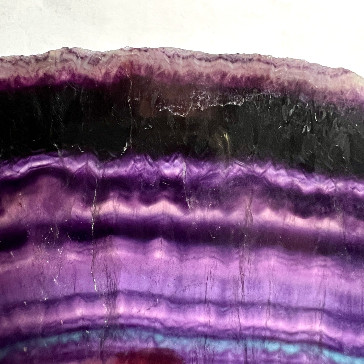 Regenbogenfluorit Platte mit deutlichen Bandzonen in Violett, Schwarz und Hellrosa, gewellte Struktur | Happy Minerals