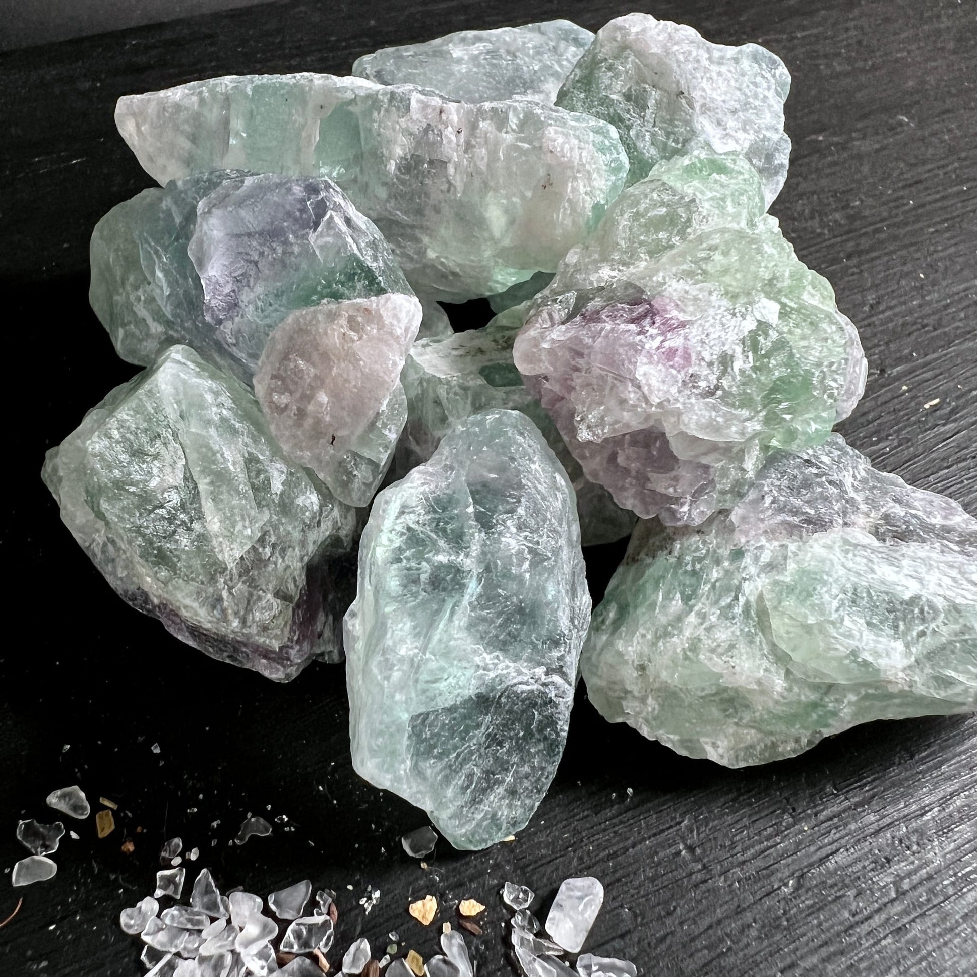 Regenbogenfluorit Rohsteine | mintgrün | lila | gestapelt | Schwarzer Hintergrund | Happy Minerals