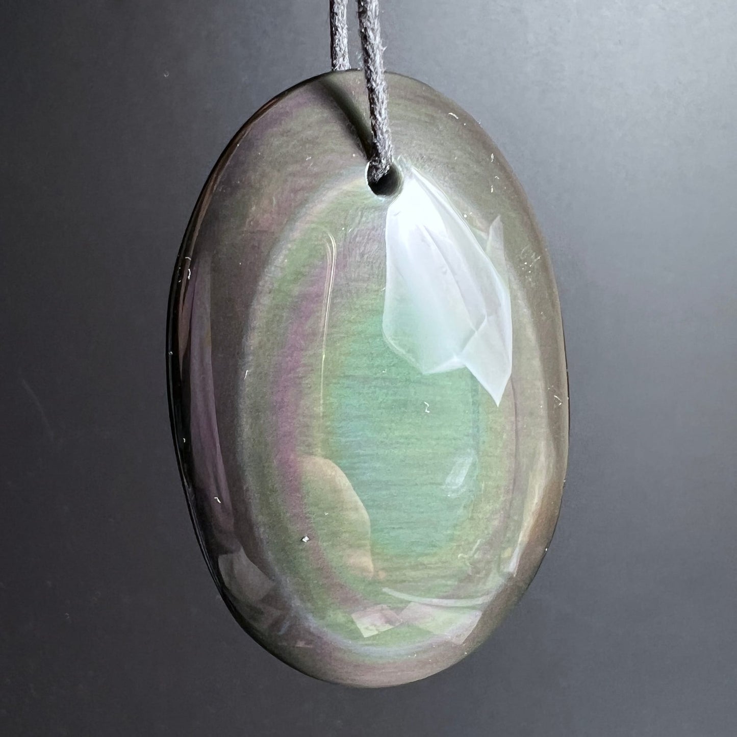 Regenbogenobsidian Anhänger oval poliert, dunkel mit schimmernden grün-violetten Farbzonen und seidigem Lichtreflex | Happy Minerals