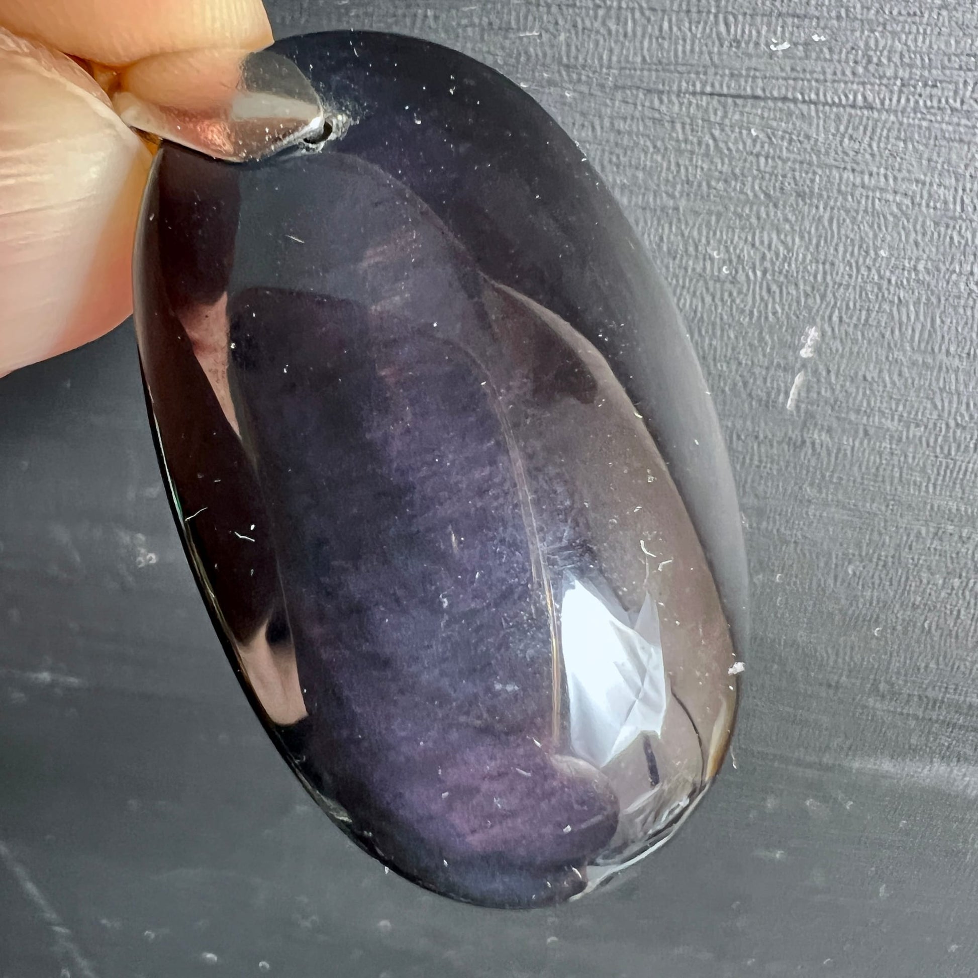 Regenbogenobsidian Anhänger | violett-lila Schimmer | in der Hand gehalten | Rückseite | Happy Minerals | Unikat Mexiko