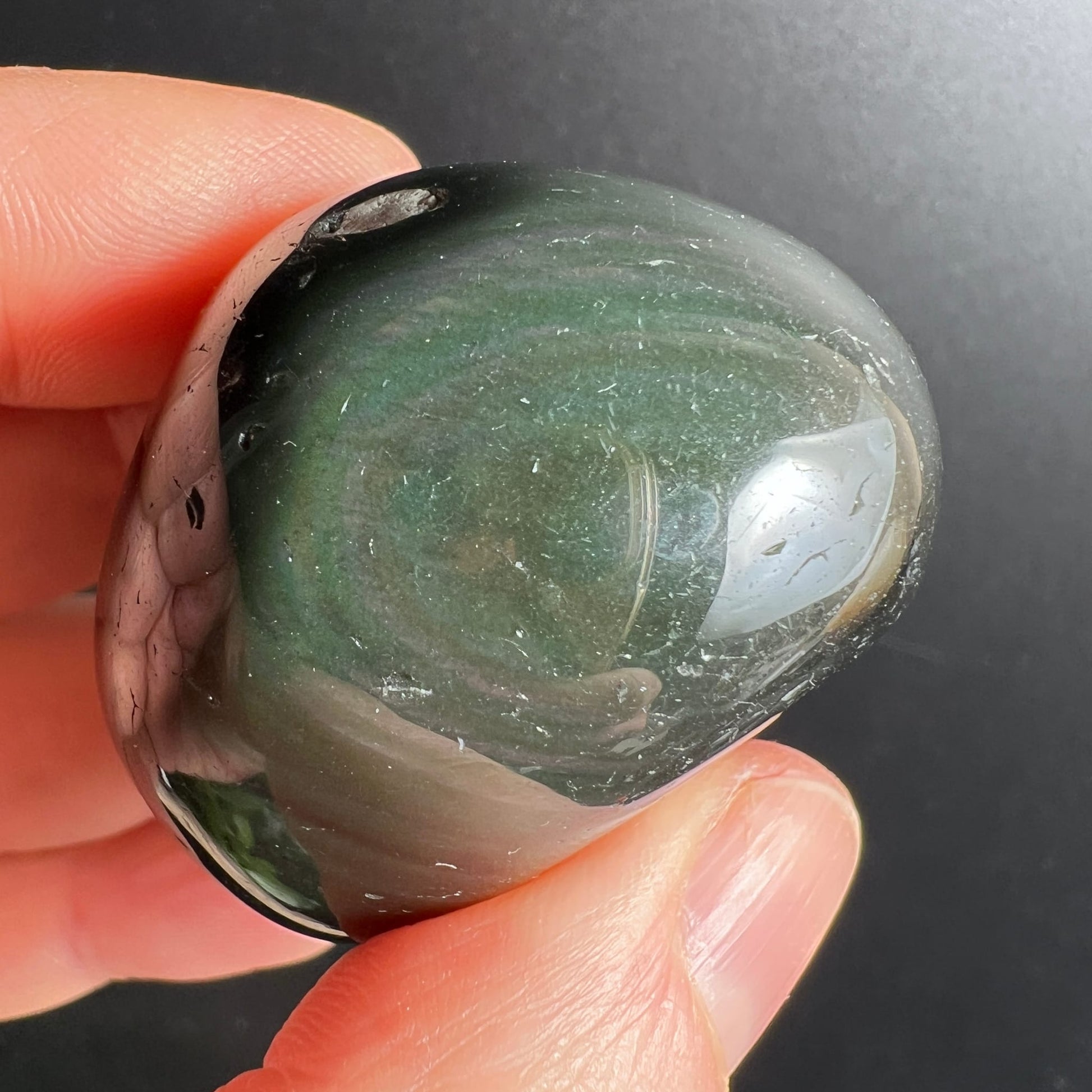 Regenbogenobsidian Trommelstein, dunkelgrün mit schimmernden Lichtreflexen, cremig-graue Zonen, ovale polierte Form | Happy Minerals