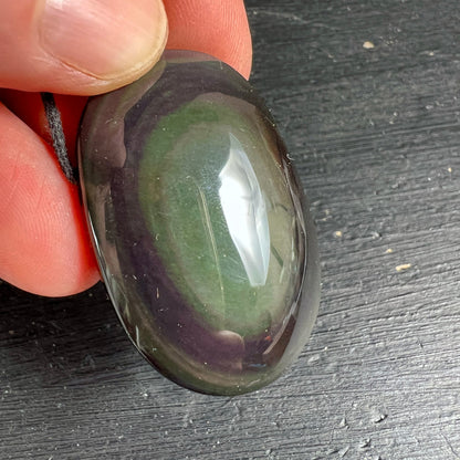 Regenbogenobsidian Nahaufnahme | lebendiges Grün mit Violett-Rand | zwischen Fingern | Happy Minerals
