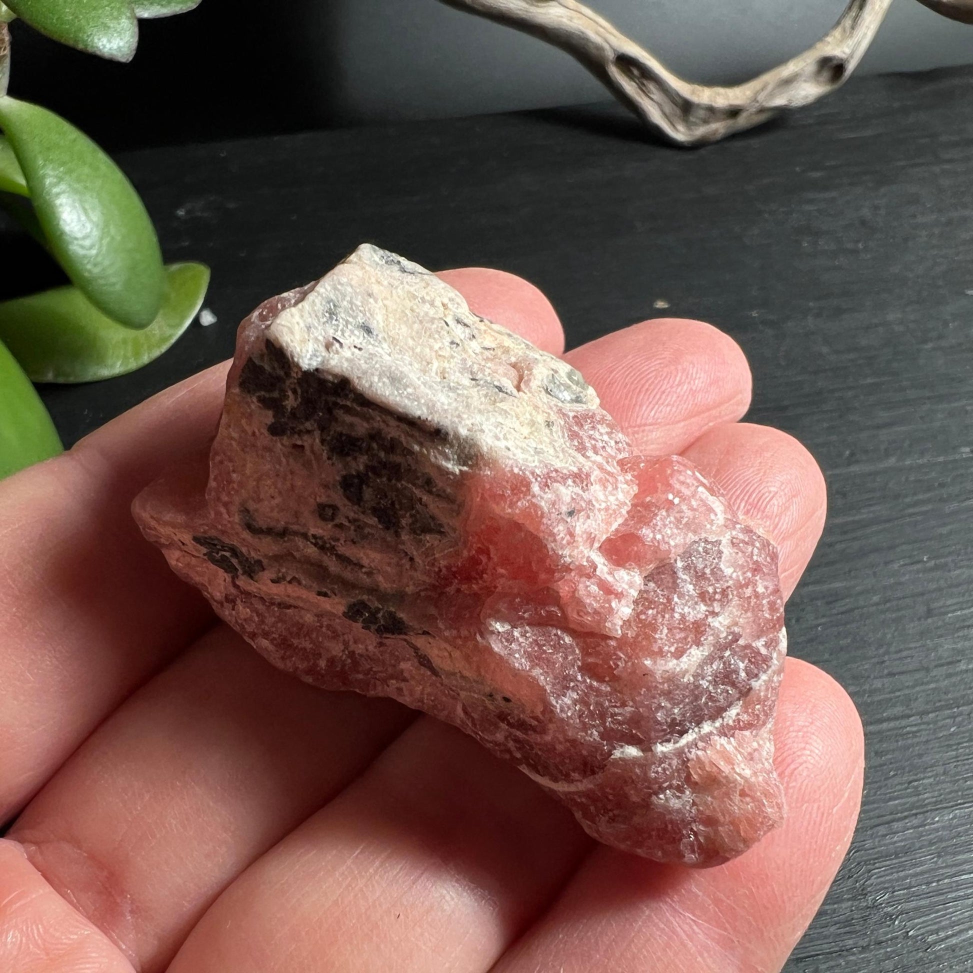 Roher Rhodochrosit in der Hand Groessenvergleich 52 mm