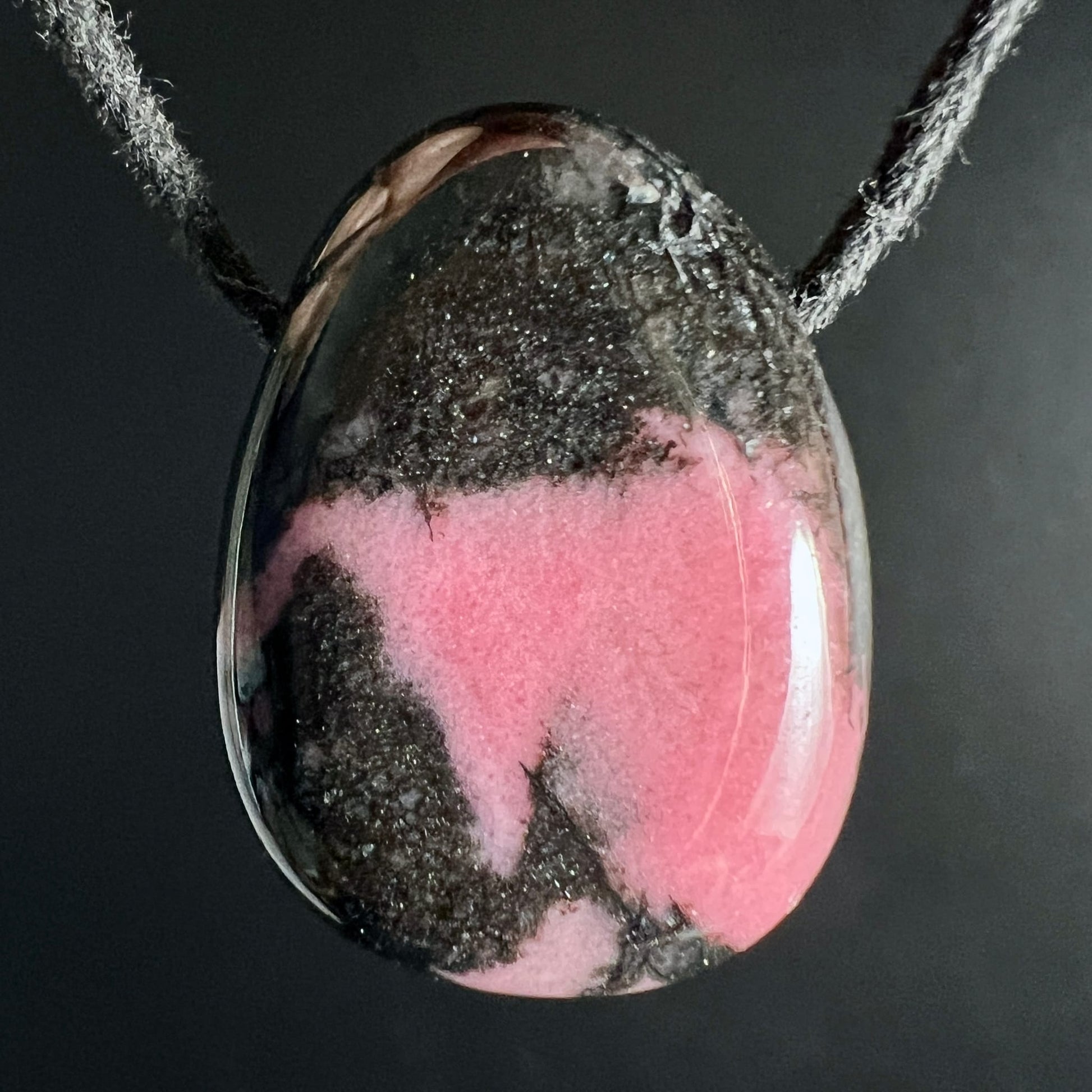 Rhodonit Anhänger Tropfenform, kräftig pinkes Rosa mit schwarzen Manganadern und glitzernden Einschlüssen | Happy Minerals