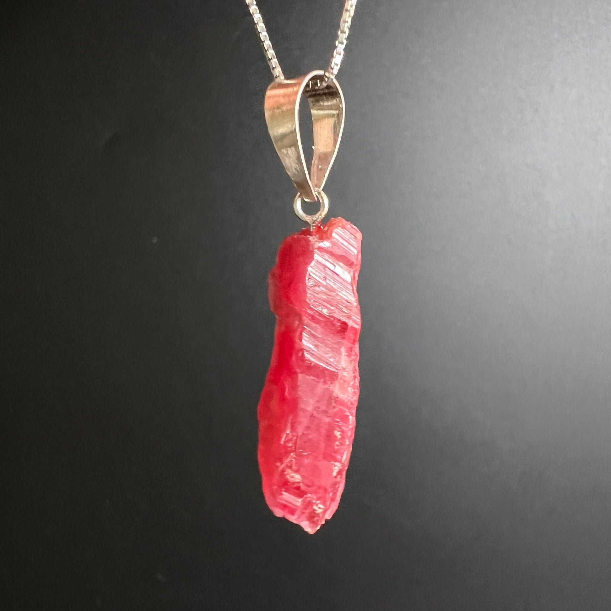Rhodonit Anhänger roh, leuchtend korallenrot mit silbrigen Glanzflächen, längliche Stabform, natürliche Bruchstruktur | Happy Minerals