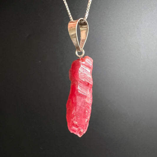 Rhodonit Anhänger roh, leuchtend korallenrot mit silbrigen Glanzflächen, längliche Stabform, natürliche Bruchstruktur | Happy Minerals