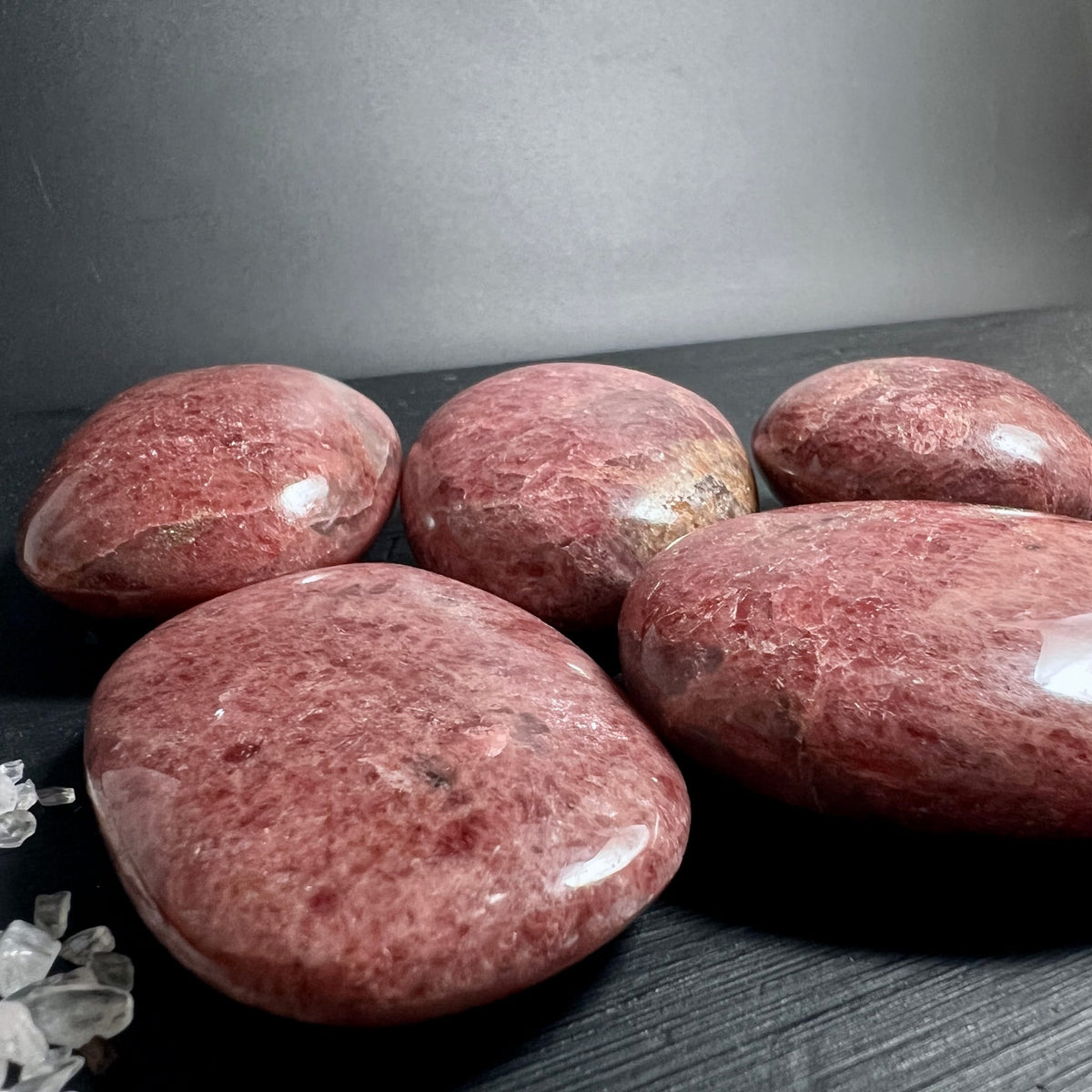 Fuenf Rhodonit Handschmeichler in rosa-rot mit dunkleren Sprenkeln, flach poliert und hochglaenzend | Happy Minerals