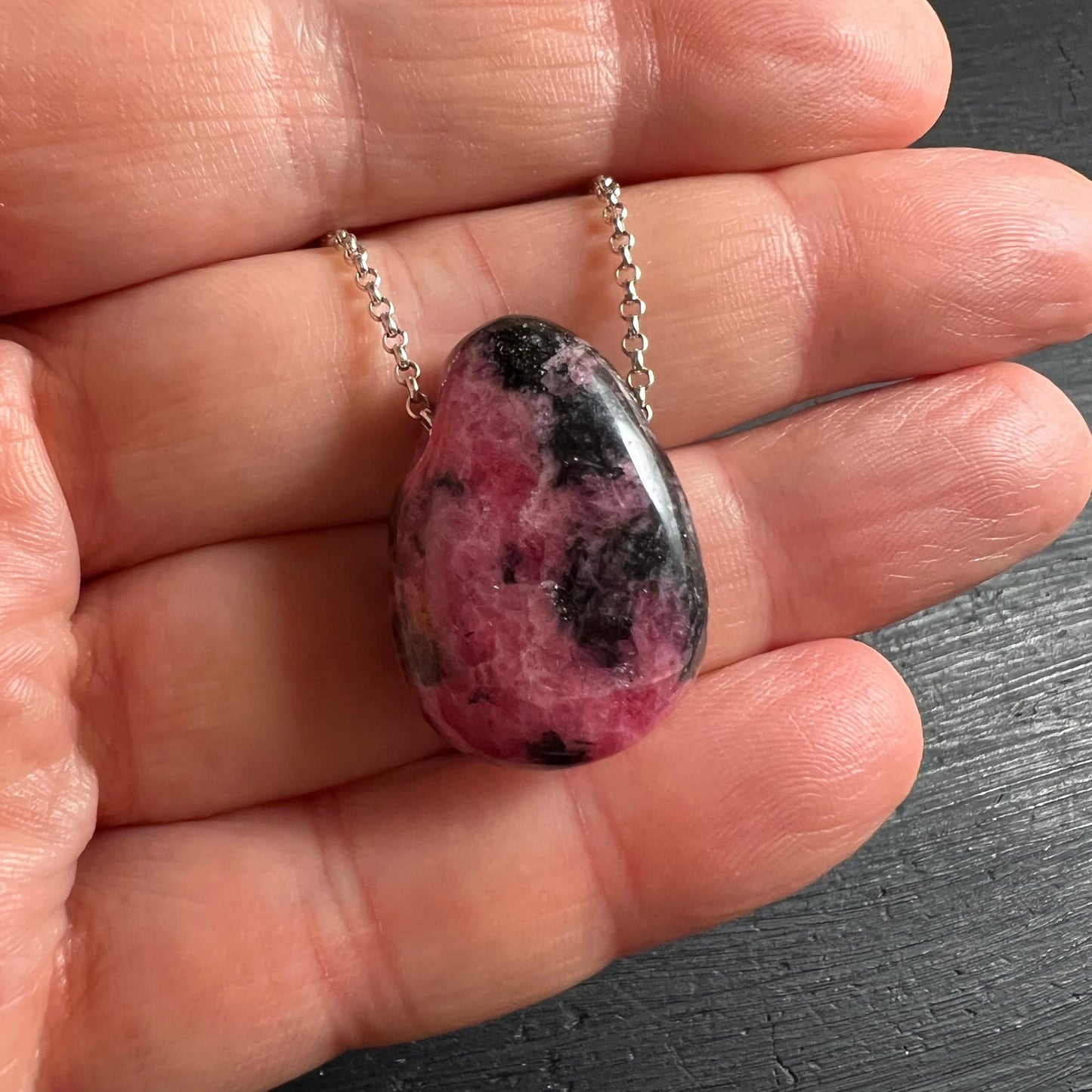 Rhodonit Tropfen in der Hand | Größenverhältnis | tiefes Pink & Schwarz | Silberkette | Happy Minerals