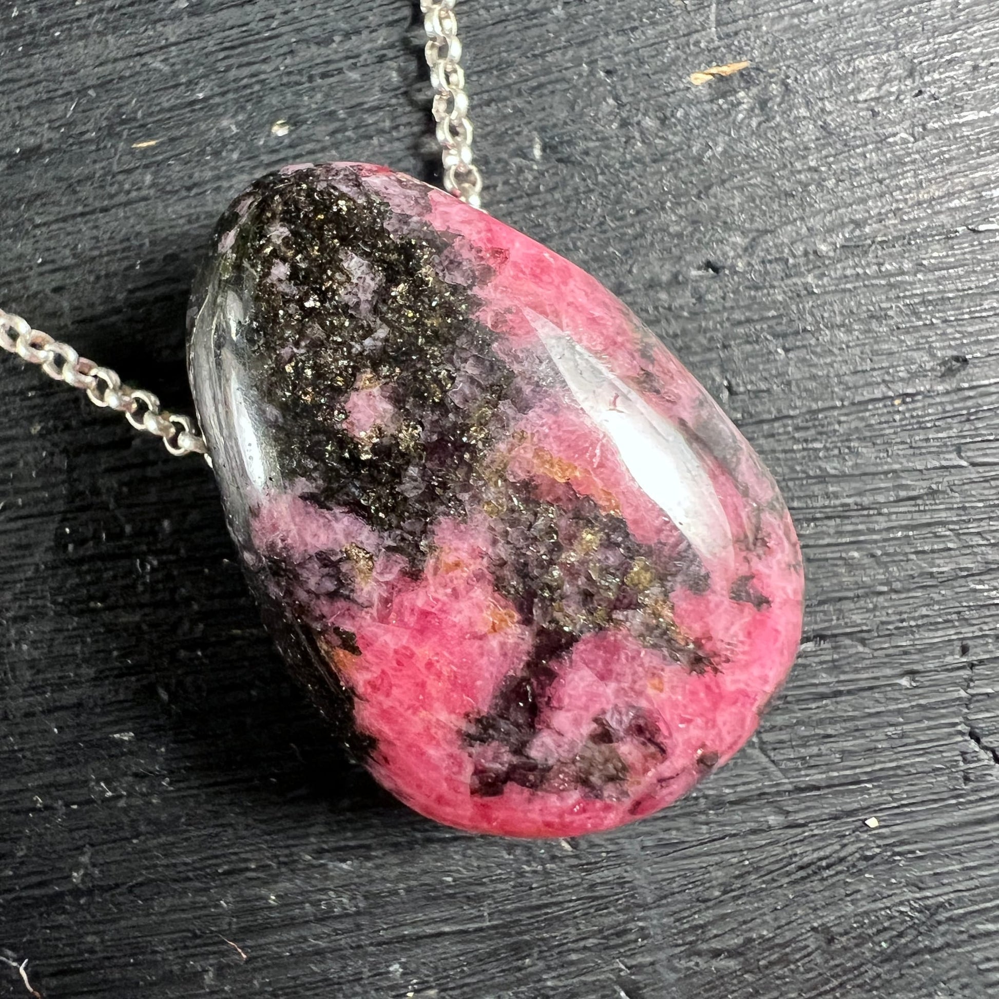 Rhodonit Unikat Nahaufnahme | pinke & schwarze Muster | seitliche Ansicht | Silberkette | Happy Minerals