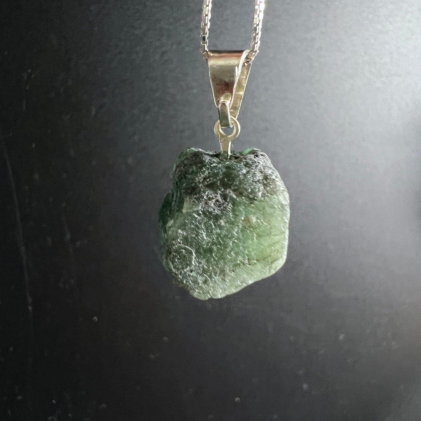 Roher Smaragd Anhänger, dunkel- bis hellgrün mit rauer Oberfläche, Einschlüssen und kreisförmiger Vertiefung, Silberöse | Happy Minerals