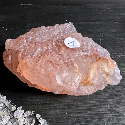 Rosa Chalcedon Rohstein Nr. 1 Variante 4 | Nahaufnahme | wellige Oberfläche | honigrosa Glanz | Happy Minerals