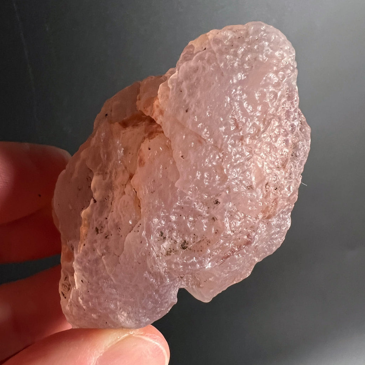 Rosa Chalcedon Rohstein Nr. 1 Variante 5 | in Hand gehalten | zarte Transparenz | Malawi-Fund | Happy Minerals