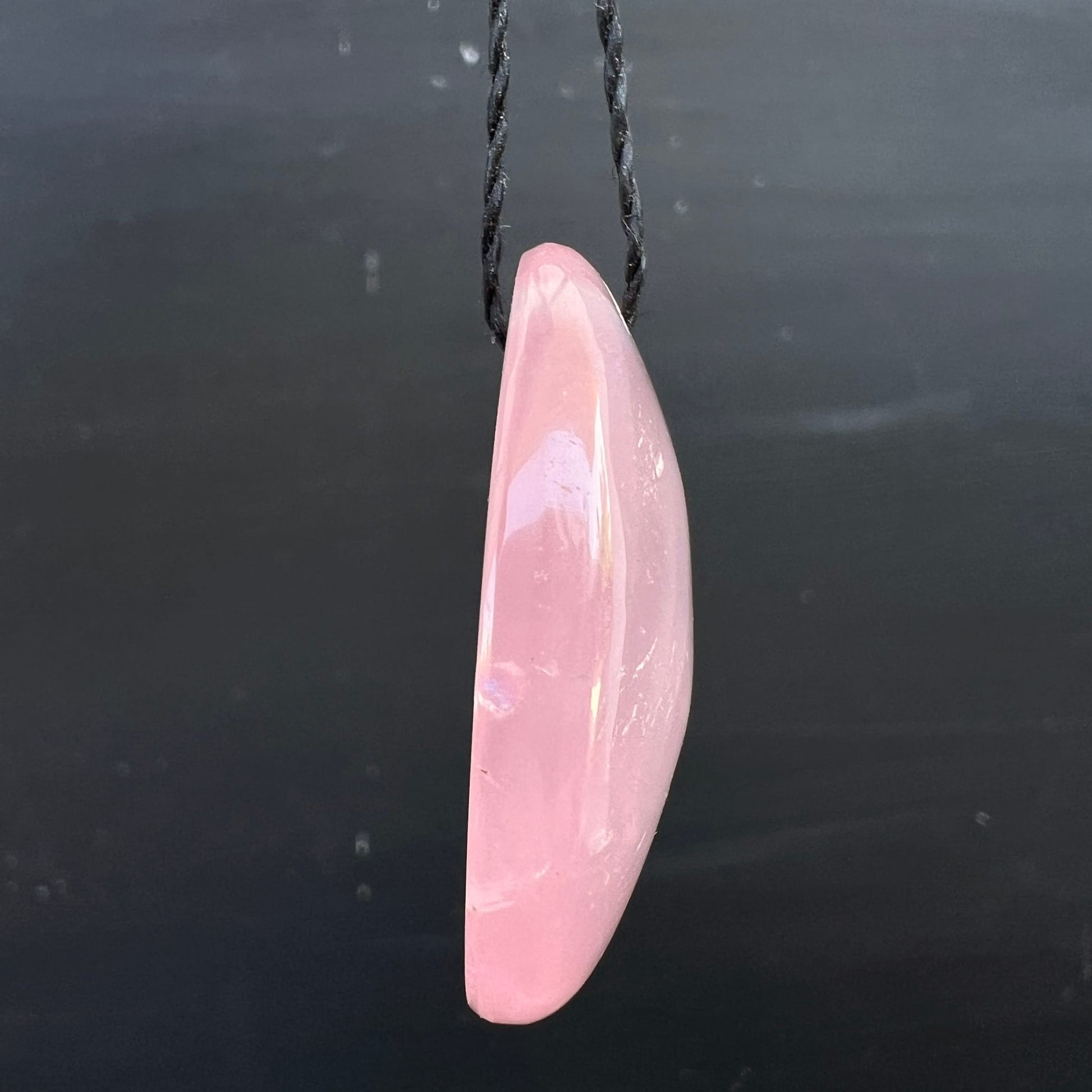 Rosenquarz Anhänger oval, zartrosa poliert, leicht konkav, schimmernder Lichtreflex, schwarze Kordel | Happy Minerals