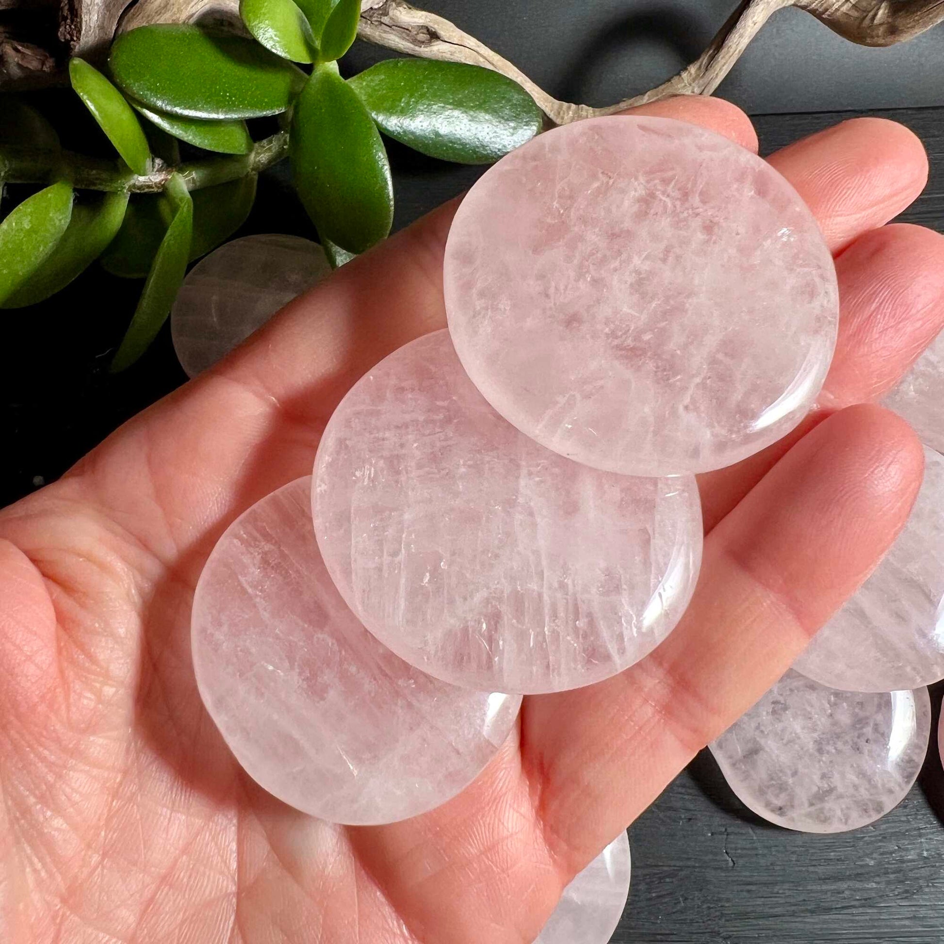 Mehrere Rosenquarz Palmstones in der Hand