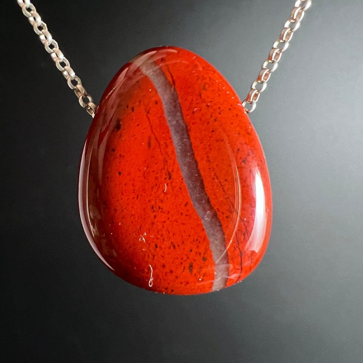 Roter Jaspis Anhaenger tropfenfoermig, poliert, mit heller Ader und dunklen Sprenkeln, glaenzend | Happy Minerals