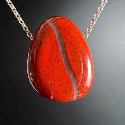 Roter Jaspis Anhaenger tropfenfoermig, poliert, mit heller Ader und dunklen Sprenkeln, glaenzend | Happy Minerals