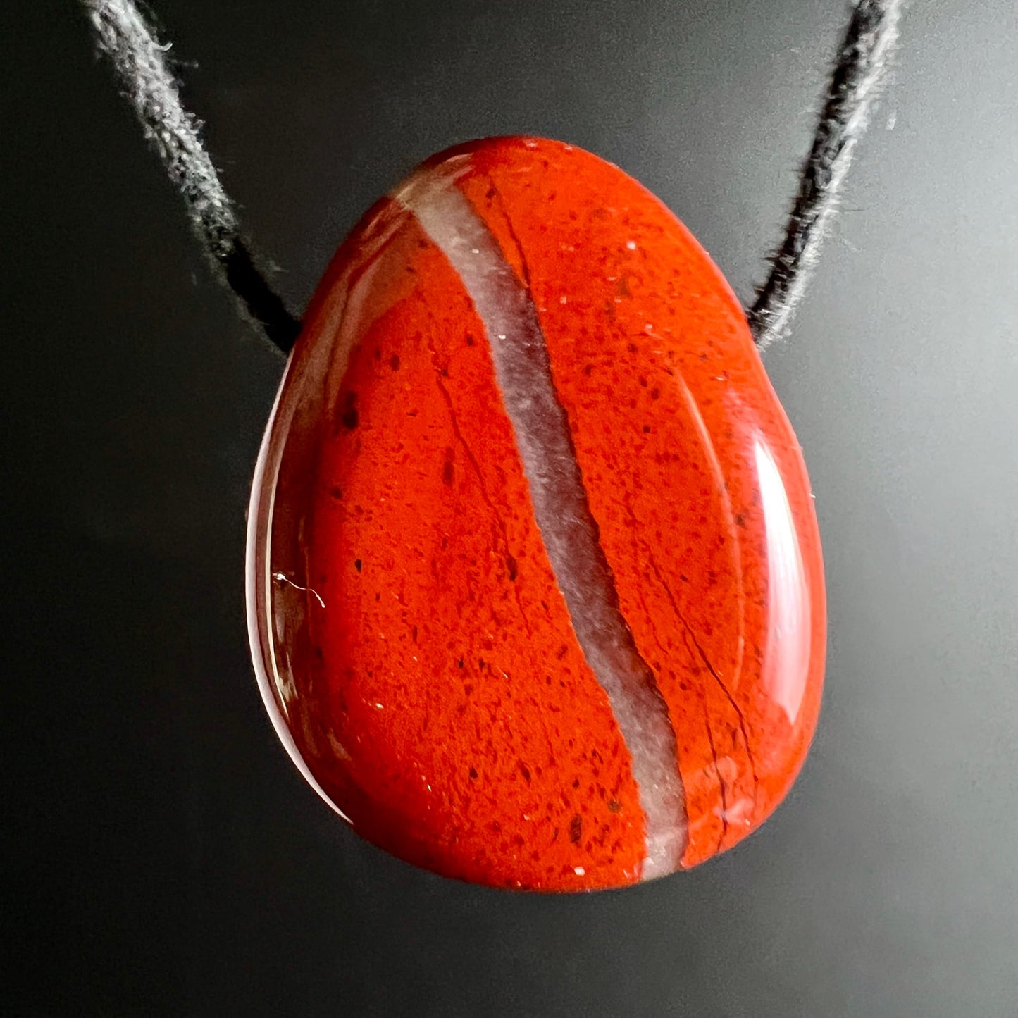 Roter Jaspis Anhaenger, tropfenfoermig poliert, mit heller Quarzader diagonal, dunkle Sprenkel | Happy Minerals