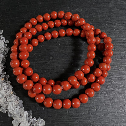 Roter Jaspis Namibia | feurig rote Kugelkette | kreisförmig drapiert auf schwarzem Untergrund | Happy Minerals