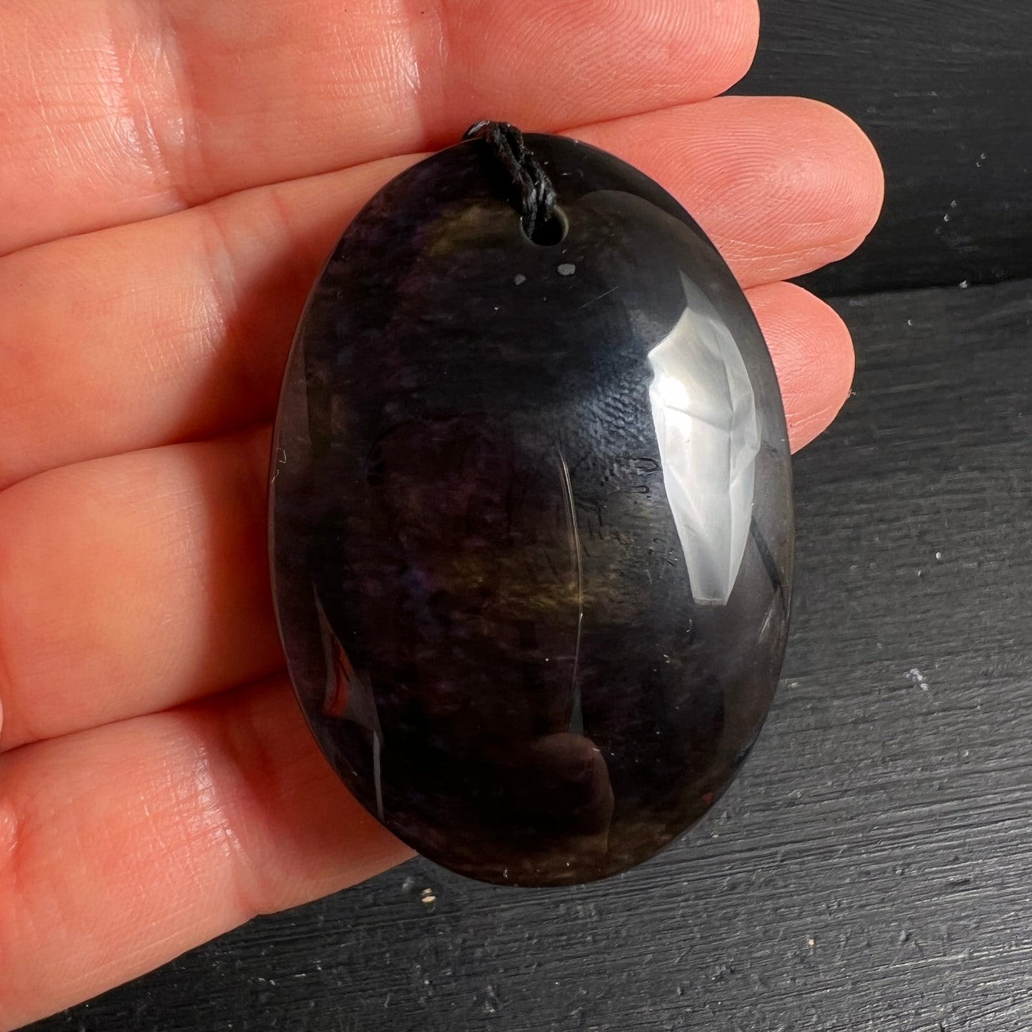 Royal Velvet Obsidian in Hand | Größenvergleich | dunkel-violett | weißer Lichtblitz | oval poliert | Happy Minerals