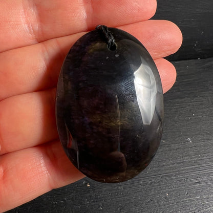Royal Velvet Obsidian in Hand | Größenvergleich | dunkel-violett | weißer Lichtblitz | oval poliert | Happy Minerals
