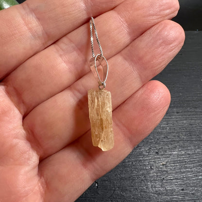 Scapolith Rohstein | honigfarben | in der Hand | zarte Silberkette | Größenverhältnis | handgefertigt | Happy Minerals