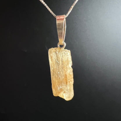 Scapolith Rohstein | warmes Bernsteinlicht | faserige Oberfläche | Silberkette | seitliche Ansicht | Unikat | Happy Minerals