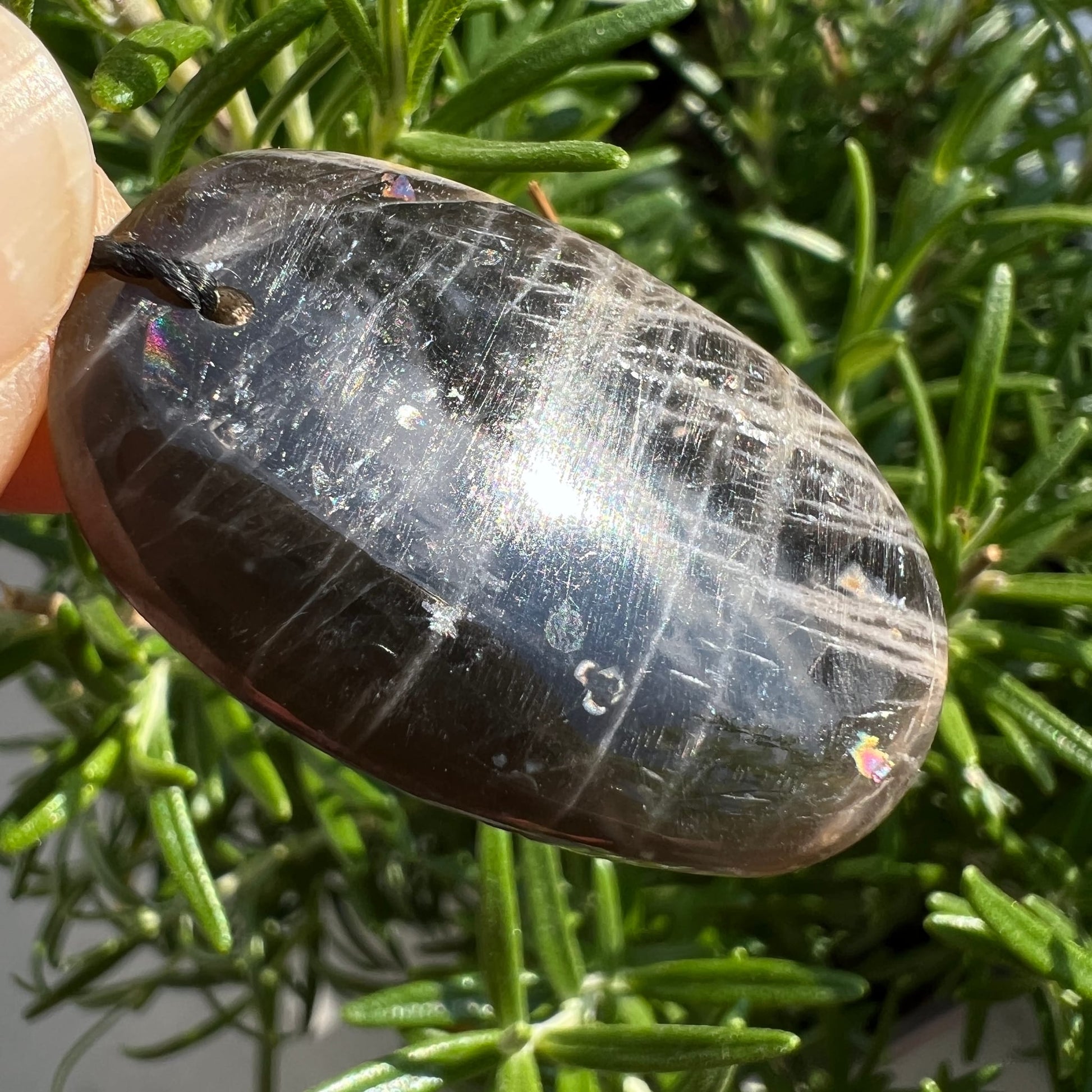 Schwarzer Mondstein Anhaenger oval poliert, dunkelgraue Flaechen mit feinen Kratzstrukturen und Regenbogenschimmer | Happy Minerals