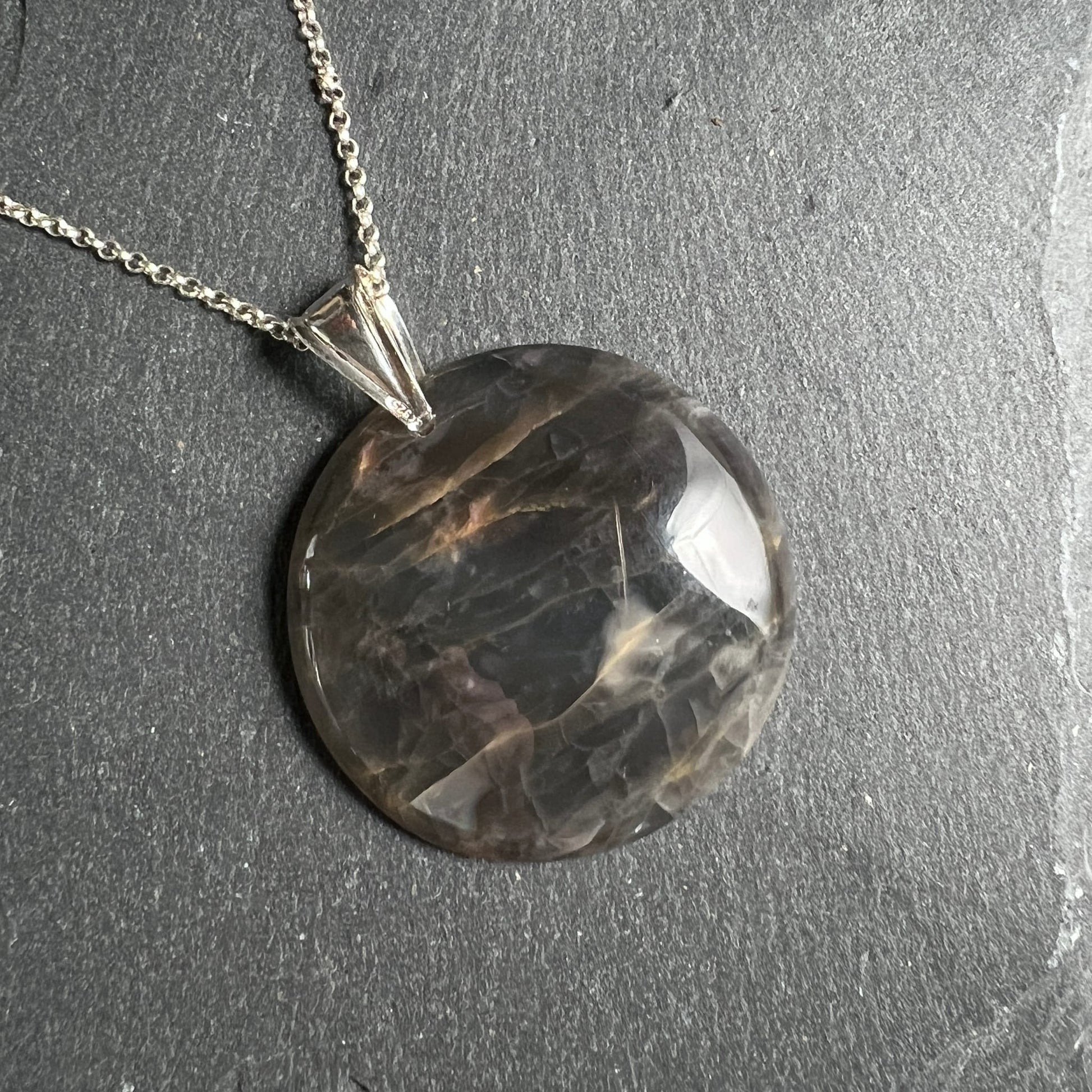 Schwarzer Mondstein Anhänger, rund poliert, dunkelgrau-schwarz mit goldbraunen Schlieren und Schimmer | Happy Minerals