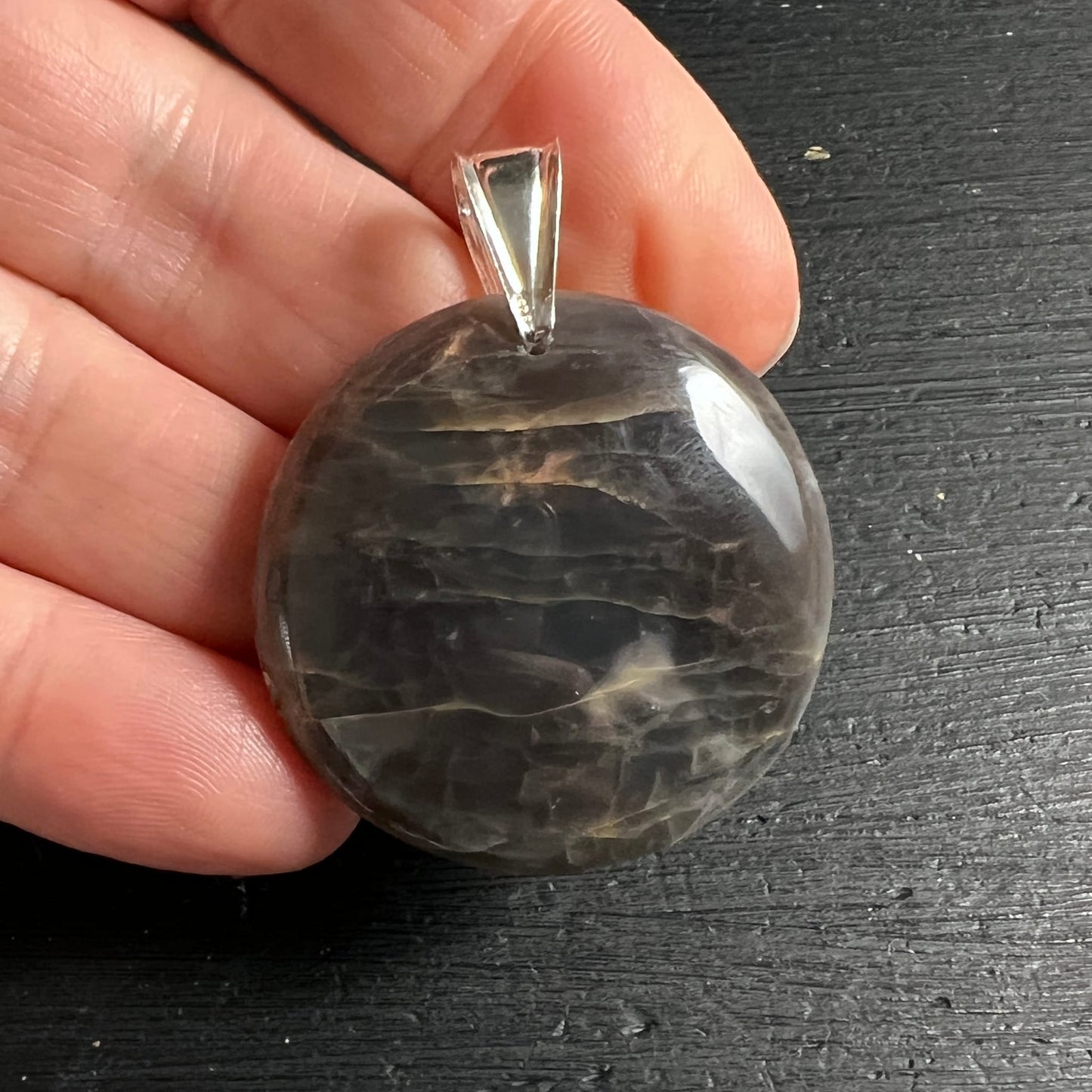 Schwarzer Mondstein Anhänger, rund poliert, dunkelgrau mit welligen beige-braunen Schlieren und Seidenglanz | Happy Minerals