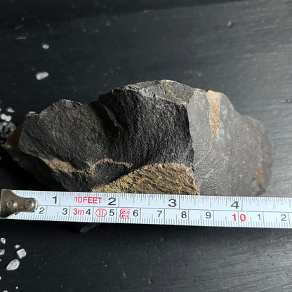 Roher schwarzer Onyx Stein mit rauer Bruchkante, grauen Zonen und gelblich-olivfarbenen Adern | Happy Minerals