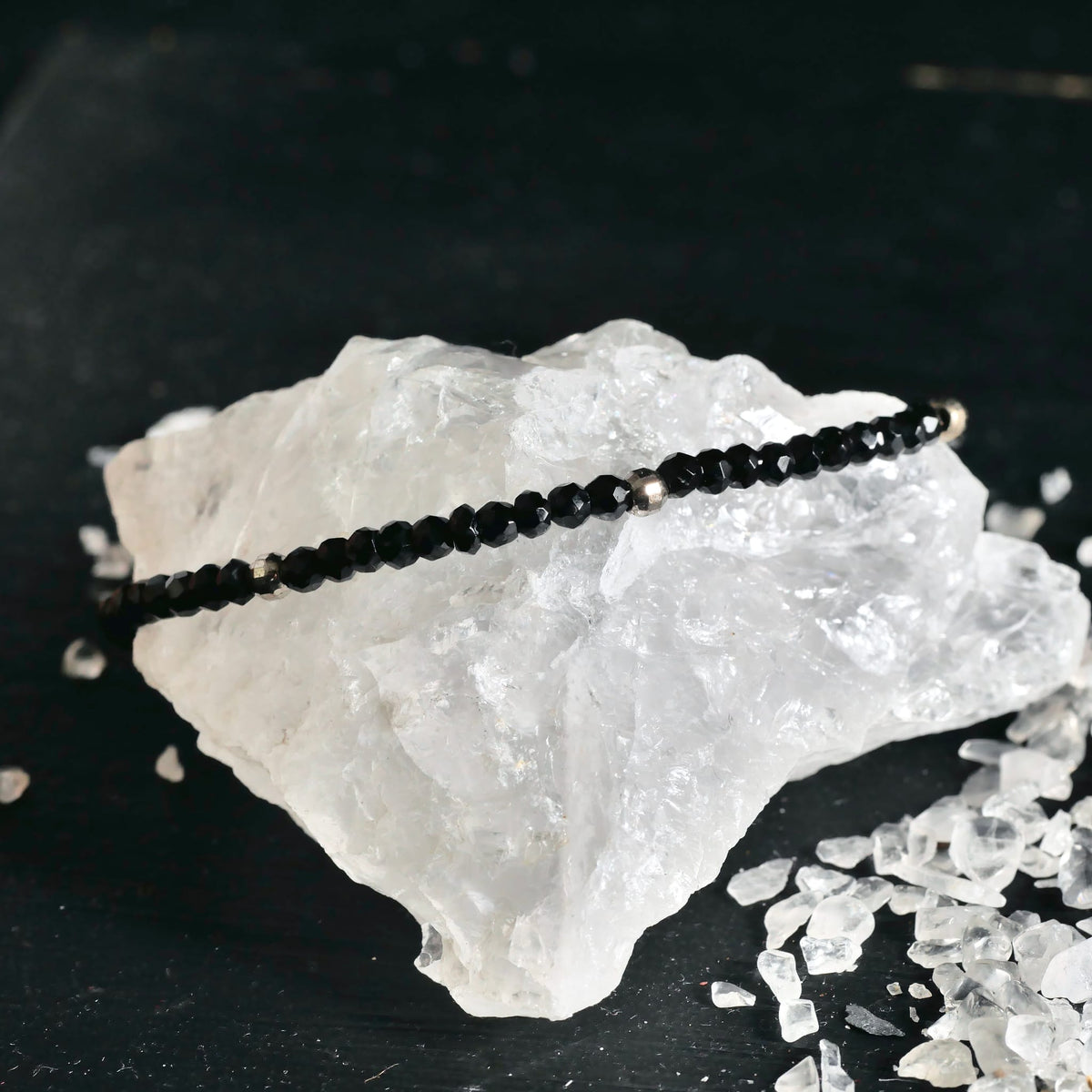 Spinell Armband elegant platziert auf Kristallgestein | changierende Facetten | Happy Minerals Schmuckstück