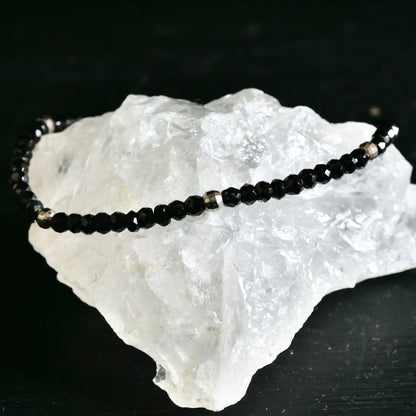 Nahaufnahme facettierte Spinell Kugeln auf weißem Bergkristall | glänzend schwarz-silber | Happy Minerals