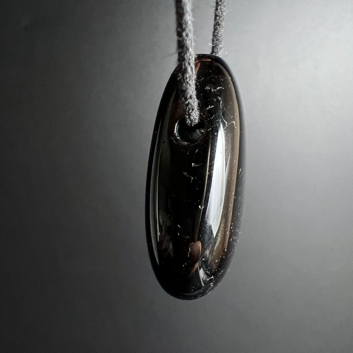 Schwarzer Turmalin Anhaenger oval poliert, glaenzend mit rotbraunen Schimmer und gebohrtem Loch | Happy Minerals