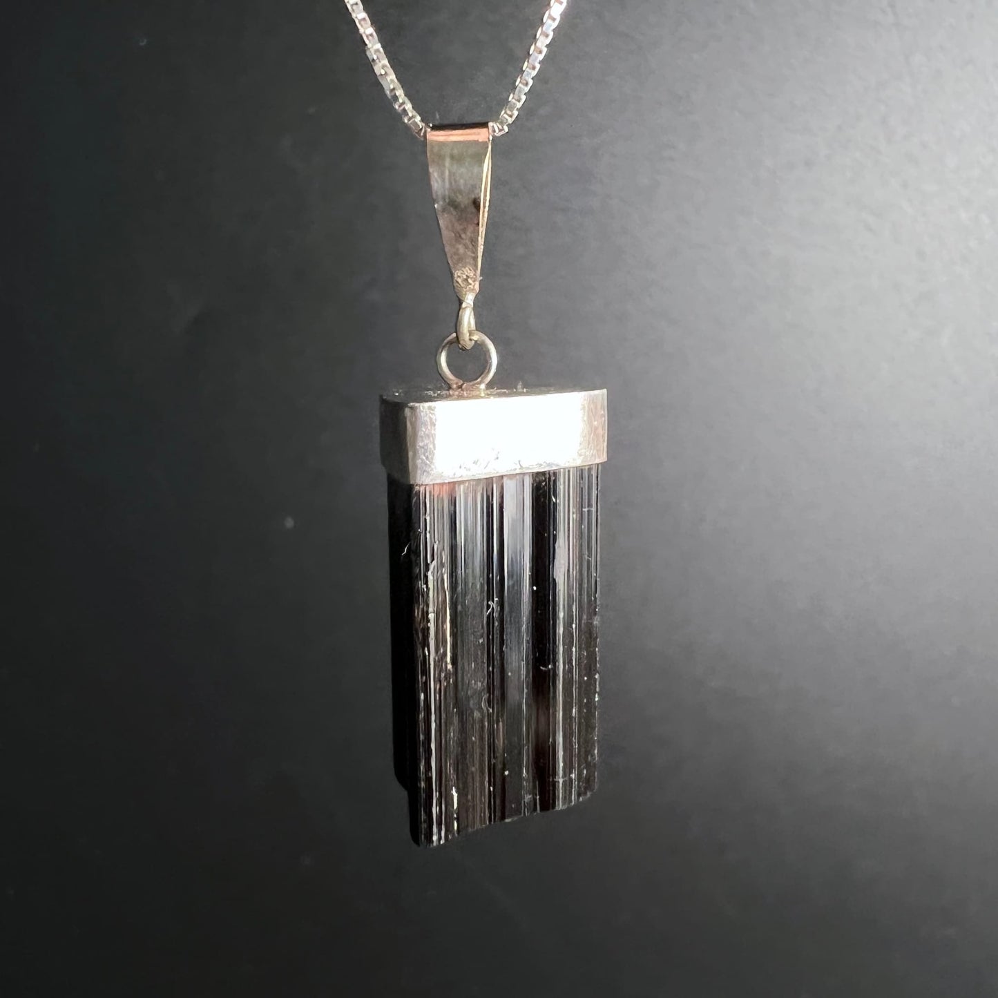 Schwarzer Turmalin Anhänger | seitliche Ansicht | markante Silberkappe | tiefschwarze Streifen | Happy Minerals