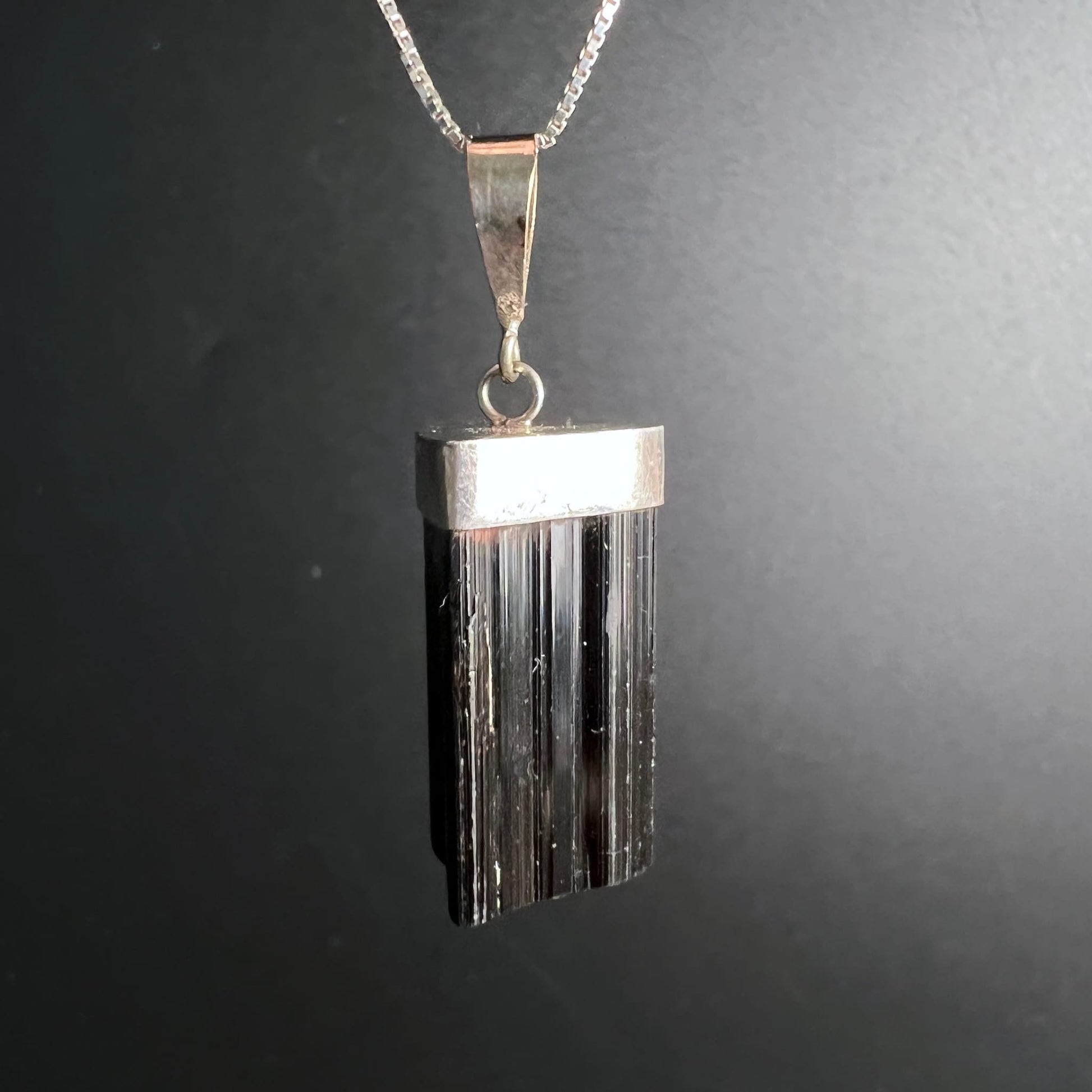 Schwarzer Turmalin Anhänger | seitliche Ansicht | markante Silberkappe | tiefschwarze Streifen | Happy Minerals