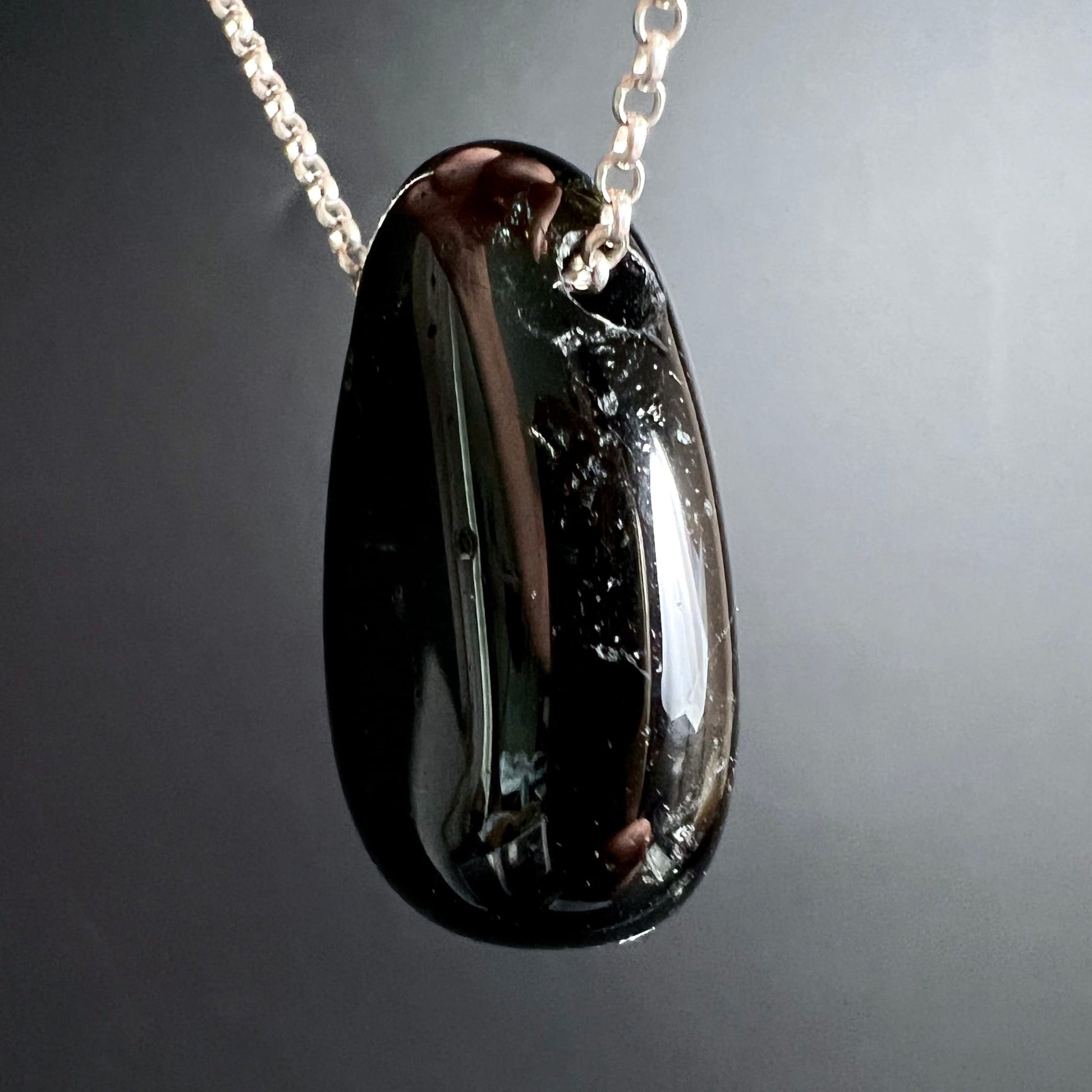 Schwarzer Turmalin Anhänger, tropfenförmig poliert, tiefschwarz mit spiegelndem Glasglanz und silbrigen Lichtreflexen | Happy Minerals