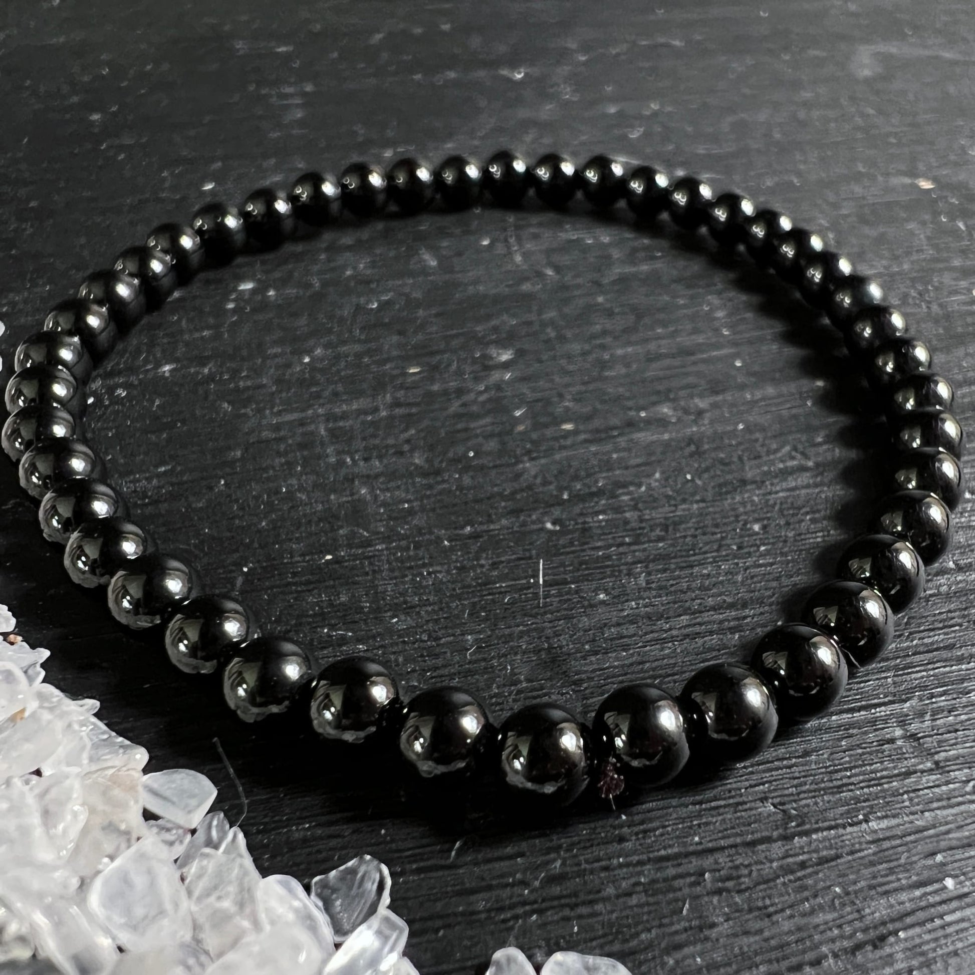 Schwarzer Turmalin Armband, hochglanzpolierte tiefschwarze Kugelperlen 3-4mm, groessere Perlen vorne, elastisch | Happy Minerals