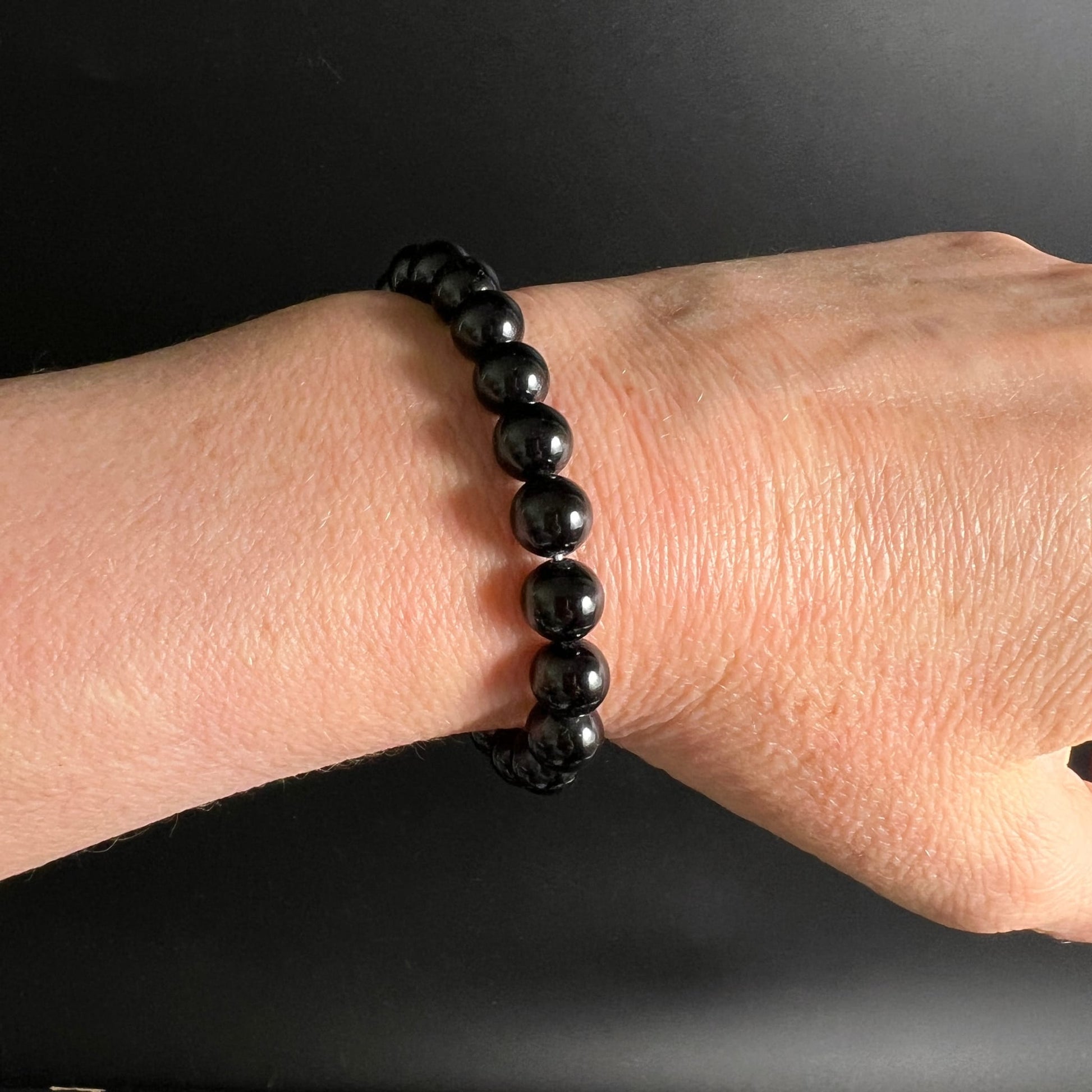 Schwarzer Turmalin Armband, glänzende tiefschwarze runde Perlen ca. 8mm, gleichmässig aufgereiht am Handgelenk | Happy Minerals