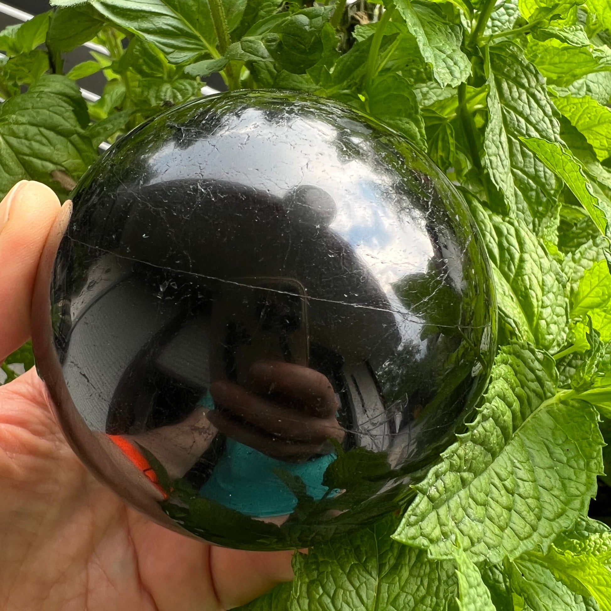 Schwarzer Turmalin Kugel 73mm, tiefschwarz glänzend mit silbrig-weissen Rissen, spiegelnde Oberfläche | Happy Minerals